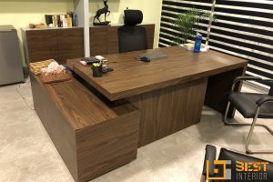 Modern executive office with walnut L-shaped desk, ergonomic chair, and storage cabinets by Best Interior