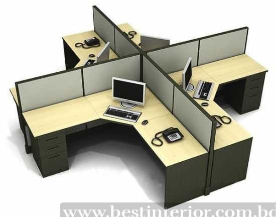 Cross-shaped office workstation with phone, monitor, and fabric partitions.