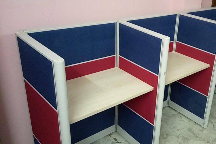 Wall-side seating workstation with aluminium frame and fabric panels in blue and red.