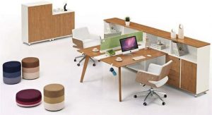 Modern office setup with a wooden desk, ergonomic chair, storage units, and colorful stools.