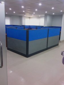 Blue and gray modular office cubicle workstations in a modern open-plan layout