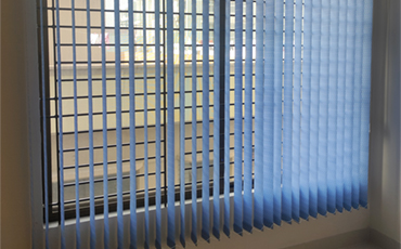 Blue vertical blinds hanging over a window.