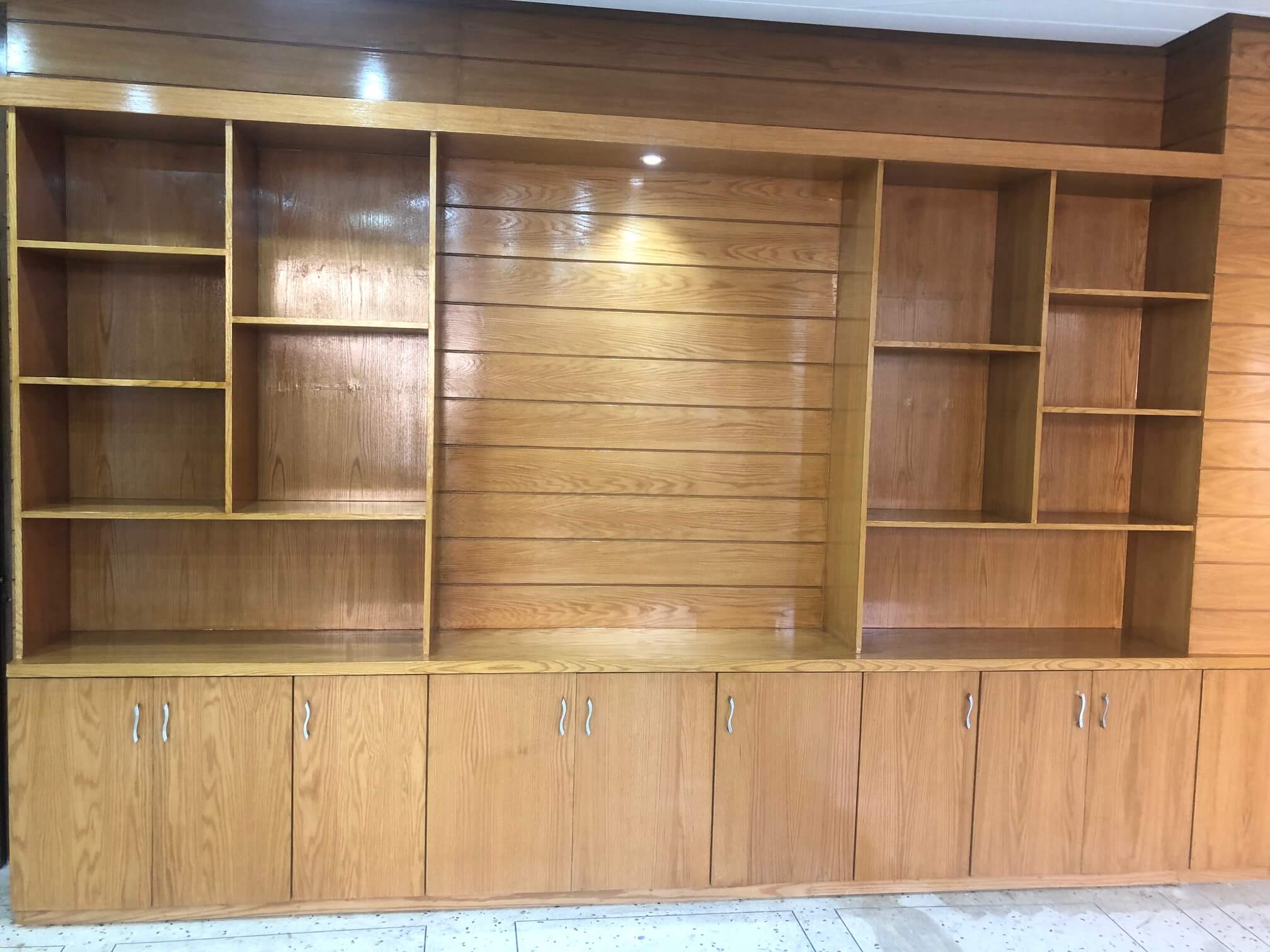 Wooden cabinet with open shelves and closed compartments, designed for organized storage and display.