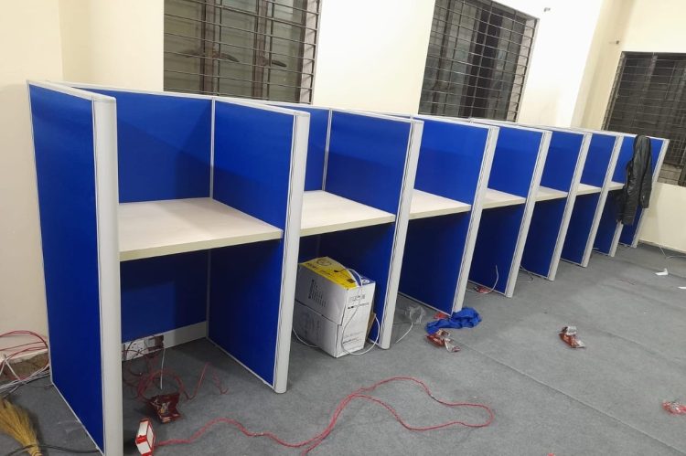 Wall-facing office cubicle workstation featuring a single-color fabric partition and aluminum frame, designed for efficient workspace utilization.